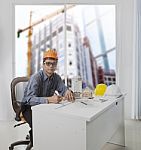 Architect Engineer Working In Office Room Against Building Const Stock Photo