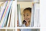 Asian Children Choosing A Book In The Library Stock Photo