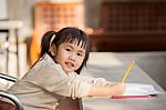 Asian Children With Yellow Pencil In Hand Doing School Home Work With Happiness Emotion Stock Photo