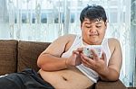 Asian Fat Man Relaxing In The Sofa With The Tablet Stock Photo