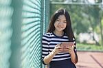 Asian Girl And Computer Tablet In Hand Standing With Toothy Smiling Face Stock Photo