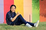 Asian Girl Relaxing Sitting On Green Grass Field Of Public Park And Hand Sign Ok ,all Right With Toothy Smiling Face Happiness Emotion Stock Photo