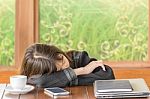 Asian Girl Sleeping While Sitting At Desk Stock Photo