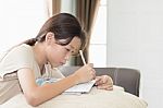 Asian Girl Writing On Lesson Book Stock Photo