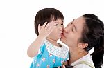 Asian Mother Carrying And Smooching Her Daughter On White Background Stock Photo