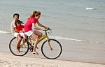 Asian Sons And Mother Riding Bicycle On Beach Stock Photo