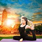 Asian Woman Health Care Yoga Posting With Asian Ancient Pagoda Temple And Sun Set Sky Stock Photo