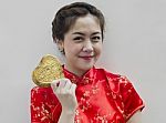 Asian Woman Holding Golden Heart Stock Photo