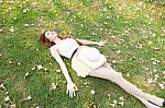 Asian Woman Lying On The Grass Stock Photo