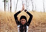 Asian Woman Meditating In Grass Field  Stock Photo