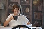 Asian Woman Smiling Face Happiness Emotion And Coffee Cup In Hand Sitting On Wood Table At Home Stock Photo