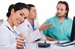 Asian Women Doctor Show Ok Sign, Two Other Team Mates Talking Deeply Stock Photo