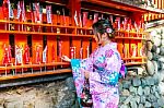 Asian Women Wearing Japanese Traditional Kimono Visiting The Beautiful In Fushimi Inari Shrine In Kyoto, Japan Stock Photo