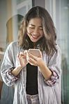 Asian Younger Woman Laughing With Happiness Emotion Looking And Message Chat On Smart Phone Stock Photo