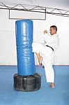 Athletic Black Belt Karate Giving A Forceful Knee Kick During A Stock Photo