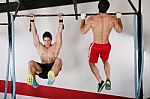 Athletic Group Executing Exercise Tightening On Horizontal Bar Stock Photo