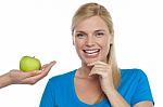 Attractive Woman Is Being Offered A Green Apple Stock Photo