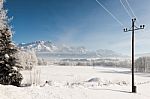 Austrian Winter Wonderland With Mountains, A Power Pole, Fresh Snow And Haze Stock Photo