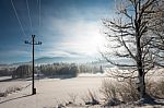 Austrian Winter Wonderland With Mountains, A Power Pole In Fresh Snow And Haze Stock Photo