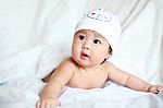 Baby With Cow Hat Lying Down On A White Blanket Stock Photo