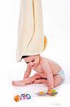 Baby With Towel On Is Head While Playing Toys Stock Photo
