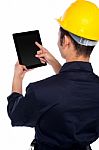 Back Pose Of Worker Operating Tablet Device Stock Photo