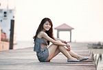 Beautiful Asian Woman Sitting On Wood Pier With Relaxing Emotion Stock Photo