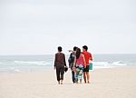 Beautiful Family Walking On Beach Stock Photo