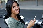 Beautiful Girl Posing At Camera In The City With Mobile Phone Stock Photo