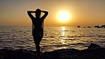 Beautiful Girl Silhouette Standing In The Sand During A Sunset On Golden Bay, Malta Stock Photo