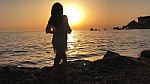 Beautiful Girl Silhouette Standing In The Sand During A Sunset On Golden Bay, Malta Stock Photo