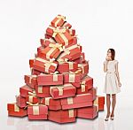 Beautiful Girl Standing Near The Pile Of Gifts Stock Photo