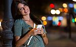 Beautiful Woman Use Her Phone In The City At Night Stock Photo