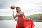 Beautiful Woman Wear Red Evening Dress Hold A Bouquet Of Flowers Stock Photo