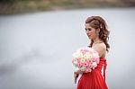 Beautiful Woman Wear Red Evening Dress Hold A Bouquet Of Flowers Stock Photo