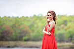 Beautiful Woman Wear Red Evening Dress Over Mountains And Rivers Stock Photo