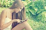 Beautiful Woman With Tablet Computer In Park Garden Stock Photo