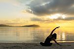 Beautiful Yoga Girl At Sunrise On The Beach Stock Photo