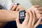Beautiful Young Couple Using A Smartwatch At Home Stock Photo
