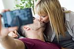 Beautiful Young Couple Using Mobile Phone At Home Stock Photo