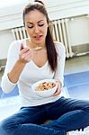 Beautiful Young Woman Eating Cereals At Home Stock Photo
