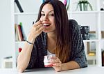 Beautiful Young Woman Eating Yogurt At Home Stock Photo