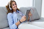 Beautiful Young Woman Listening To Music With Digital Tablet At Stock Photo