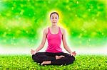 Beautiful Young Woman Practicing Yoga, Sitting In A Lotus Position Stock Photo