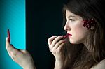Beautiful Young Woman Putting On Lipstick Stock Photo