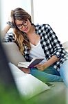 Beautiful Young Woman Reading A Book In The Sofa Stock Photo