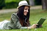 Beautiful Young Woman Using Digital Tablet In The Park Stock Photo