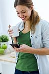 Beautiful Young Woman Using Her Mobile Phone And Enjoying Breakf Stock Photo