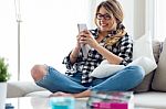 Beautiful Young Woman Using Her Mobile Phone At Home Stock Photo