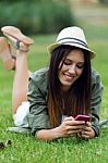 Beautiful Young Woman Using Her Mobile Phone In The Park Stock Photo